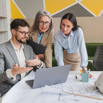Facilities management professionals meeting over property blueprints
